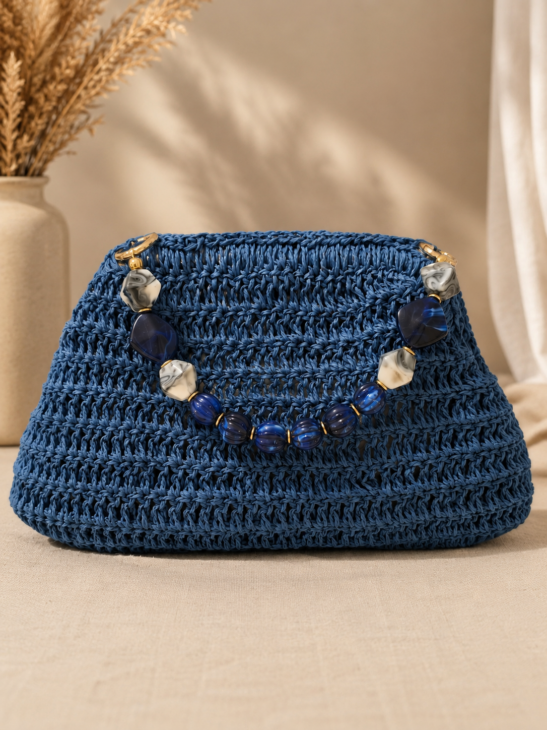 Front view of a midnight blue handmade raffia bag with a decorative blue and marbled stone handle