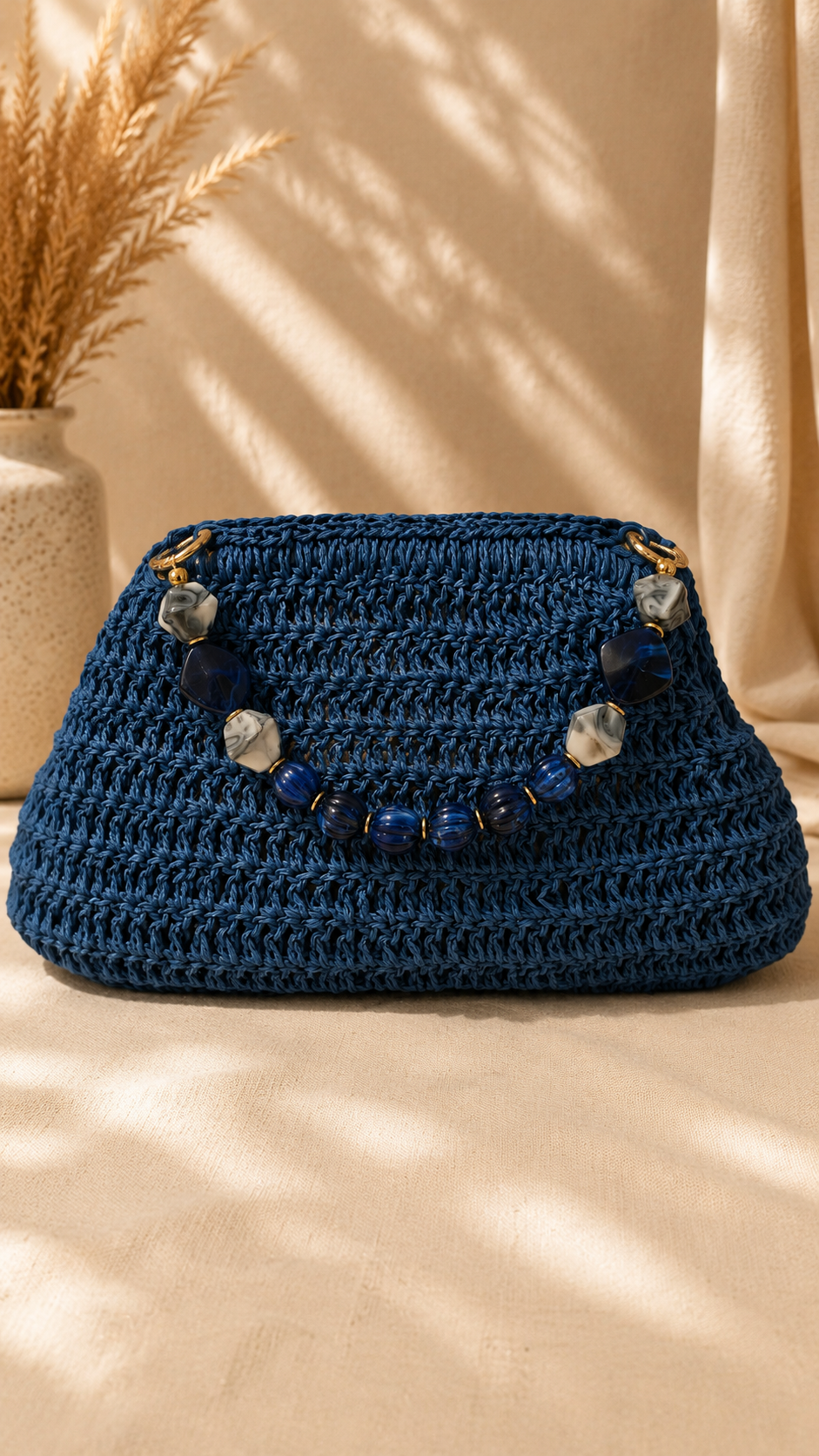 Midnight blue handmade raffia bag with a movable stone handle and gold-tone fittings